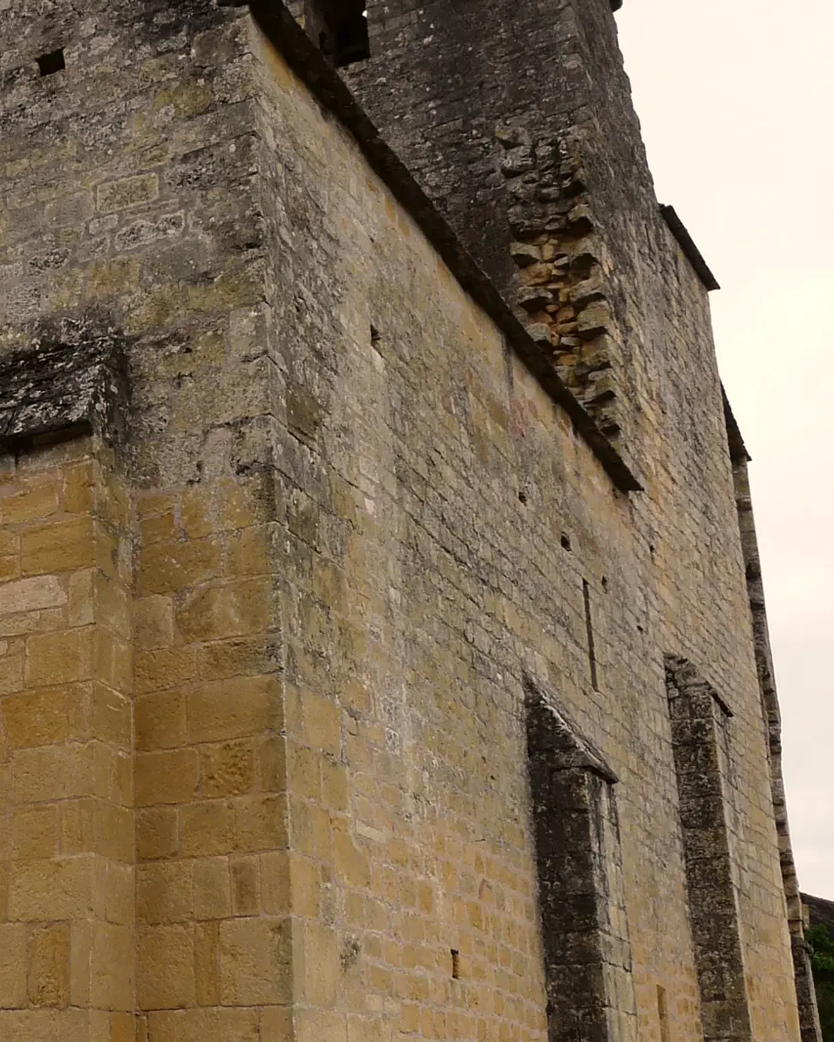 La corniche de pierre et la croix de l'église romane de Sergeac, vues d'en dessous.